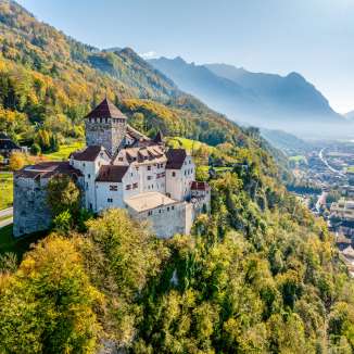 Schloss Vaduz in Liechtenstein im goldenen Herbst, mit Aussicht auf das Alpenrheintal und die Stadt Vaduz