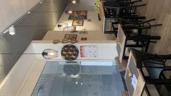 Stilvoll eingerichteter Gastraum mit schwarzen Holzmöbeln, Holzböden und kreativer Wanddekoration