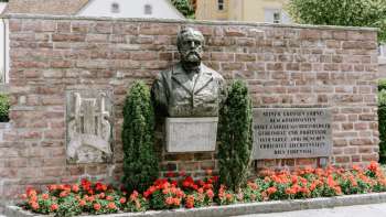 Rheinberger-Denkmal in Vaduz unter dem rote Blumen sind