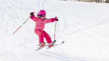 Kind in rosa Skianzug am Skifahren in Malbun