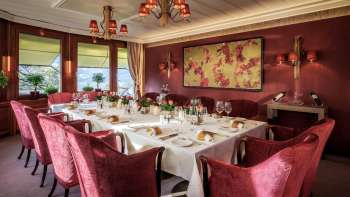 Gedeckter Tisch mit feinem Porzellan, Gläsern und Servietten unter natürlichem Licht