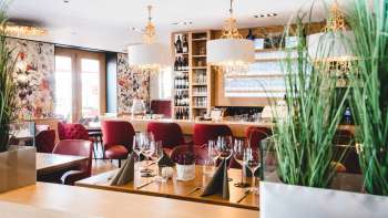 nnenraum des PUR Restaurant & Bar mit eleganten roten Polsterstühlen und stilvoll gedeckten Tischen.
