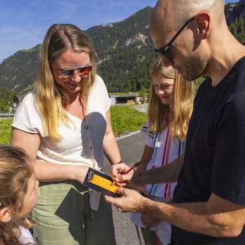 Familie trägt Minigolf-Punkte in eine Scorecard ein