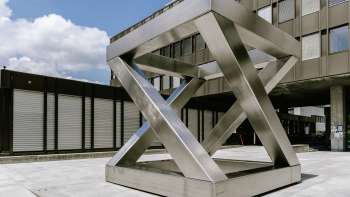 Geometrische Skulptur Z-Würfel von Georg Malin in Vaduz – versetzte Edelstahlflächen in Würfelform auf öffentlichem Platz. Geometrische Skulptur Z-Würfel von Georg Malin in Vaduz – versetzte Edelstahlflächen in Würfelform auf öffentlichem Platz.