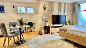 Stilvoll eingerichtetes Studio mit Kingsize-Bett, Flachbild-TV und Tisch mit zwei Stühlen