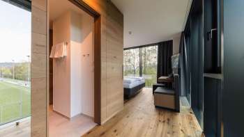 Helles Zimmer im Hotel kommod mit elegantem Holzboden und Blick ins Grüne