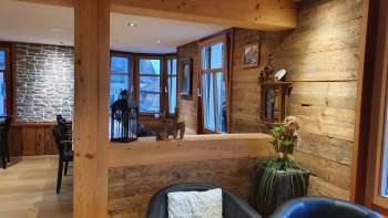 Einladender Innenbereich mit Holzwänden, stilvollem Sitzbereich und natürlicher Beleuchtung