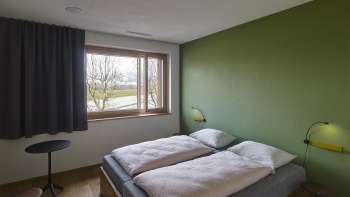 Zweibettzimmer mit grün gestrichener Wand in der Jugendherberge Schaan/Vaduz