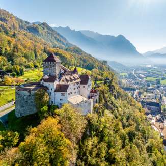 Herbstlicher Blick auf Schloss Vaduz in Liechtenstein mit Ausblick über das Rheintal