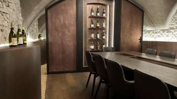 Eleganter Degustationsraum der WY Weinbar mit Gewölbedecke und edlem Holztisch für exklusive Weinverkostungen.