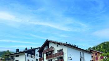 Aussenansicht des Restaurants aus einem anderen Winkel, mit dem Fokus auf die rustikale Architektur und die malerische Umgebung