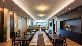 Heller Speiseraum im Restaurant Kommod mit stilvollem Design und großen Fenstern.