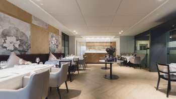 Geräumiger Essbereich mit eleganter Atmosphäre, grossen Tischen und modernen Sitzgelegenheiten