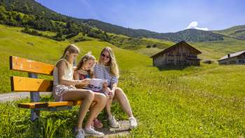 Familie beim Rätselraten während des Detektiv-Trails in Malbun