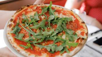 Caprese-Salat mit Tomaten, Mozzarella, Basilikum und Balsamico-Dressing, begleitet von frischem Brot