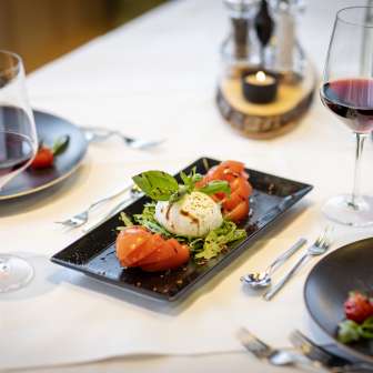Frischer Tomaten-Mozzarella-Salat mit Rotwein auf gedecktem Tisch im JUFA Hotel Malbun