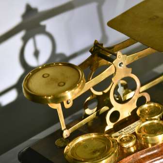 Nahaufnahme einer historischen, vergoldeten Briefwaage im Postmuseum in Vaduz – detailreiches Ausstellungsstück aus der Postgeschichte Liechtensteins.