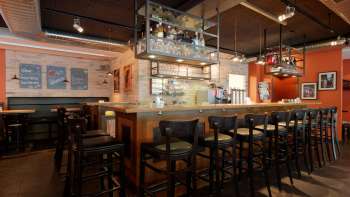 Stilvolle Innenaufnahme der Bar im New Castle Vaduz mit gut sortiertem Flaschenregal und gemütlichem Sitzbereich.