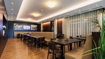 Eleganter Saal im Restaurant Kommod mit symmetrischer Anordnung und gemütlicher Atmosphäre.