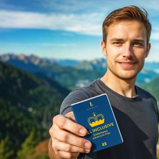 Mann zeigt den ALL INCLUSIVE Erlebnispass mit Bergpanorama im Hintergrund