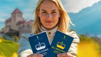 Frau präsentiert den WELCOME und ALL INCLUSIVE Erlebnispass vor Schloss Vaduz