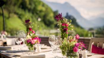 Stimmungsvoll gedeckter Tisch mit weißen Servietten, Gläsern und Besteck in modernem Ambiente