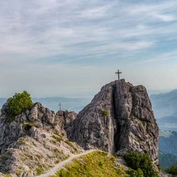 Drei Schwestern mit zwei Gipfelkreuzen und weitem Ausblick über das Tal und umliegende Berge