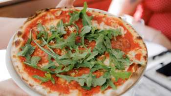 Caprese-Salat mit Tomaten, Mozzarella, Basilikum und Balsamico-Dressing, begleitet von frischem Brot