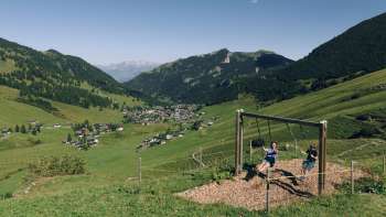 Eine Familie geniesst das gemeinsame Schaukeln auf dem Schaukelpfad in Malbun