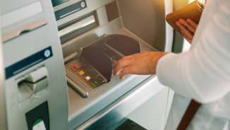 Woman pressing key pin code holding wallet on generic ATM