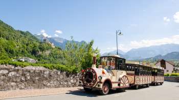 Citytrain fährt durch Vaduz mit Blick auf das Schloss Vaduz
