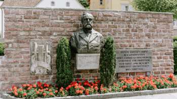 Rheinberger-Denkmal in Vaduz unter dem rote Blumen sind