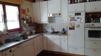 Voll ausgestattete Küchenzeile im Studio in Eschen mit Fenster, Herd, Backofen und Kühlschrank.