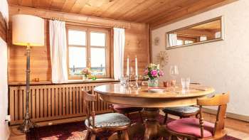 Gemütlicher Speiseraum mit Holztäfelung, rundem Esstisch und rustikalem Interieur