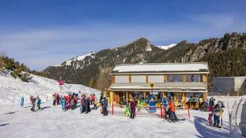 Winterlicher Skitag vor dem Malbi-Haus in Malbun – Treffpunkt für Kinder-Skikurse in Liechtensteins Familienskigebiet. Winterlicher Skitag vor dem Malbi-Haus in Malbun – Treffpunkt für Kinder-Skikurse in Liechtensteins Familienskigebiet.