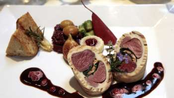 Fein angerichtetes Fleischgericht mit Beilagen auf einem stilvollen Teller