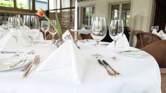 Stilvoll gedeckter Tisch mit Gläsern, Besteck und weißer Tischdecke im gehobenen Restaurant Vivid in Triesen, Liechtenstein.