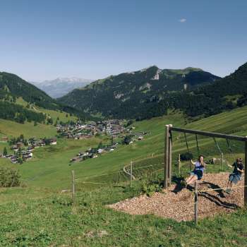 Eine Familie geniesst das gemeinsame Schaukeln auf dem Schaukelpfad in Malbun