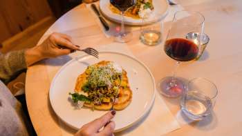 Nahaufnahme eines stilvoll angerichteten Hauptgerichts mit Rotwein im Gasthof Au.