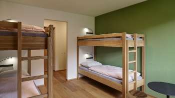 Vierbettzimmer mit Etagenbetten und Holzboden in der Jugendherberge Schaan/Vaduz
