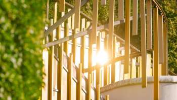 Detailaufnahme der goldenen Lamellen der Fassade des Kunstzentrums Vaduz im Gegenlicht der Sonne.