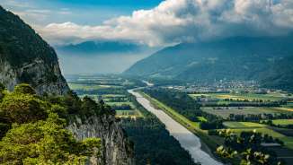 Blick vom Ellhorn in Balzers über den Rhein und das Rheintal mit Felshängen, Flussverlauf und weiter Aussicht in die Alpenregion