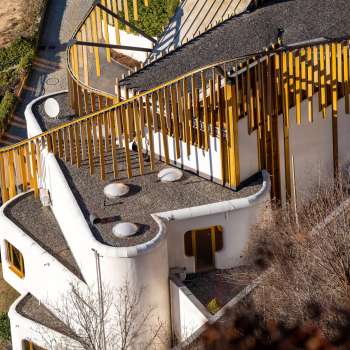 Luftaufnahme des kunstvoll geschwungenen Daches und der goldenen Fassadenelemente des Centrum für Kunst in Vaduz.