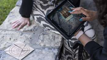 Spielerin verwendet iPad zur Rätsellösung im Outdoor Adventure Room