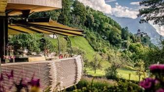 Terrasse des Park Hotel Sonnenhof in Liechtenstein mit Blick auf das Schloss Vaduz und die umliegende Alpenlandschaft