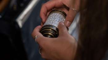 Zwei Frauen mit iPad lösen Rätsel im Outdoor Adventure Room in Malbun in alpiner Kulisse