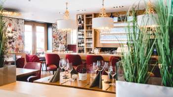 nnenraum des PUR Restaurant & Bar mit eleganten roten Polsterstühlen und stilvoll gedeckten Tischen.