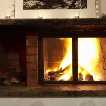 Warmer Kamin mit brennendem Holz und stimmungsvollem Licht.