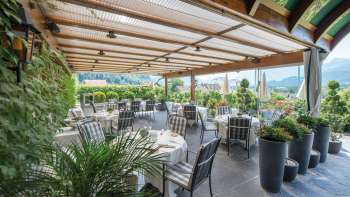 Elegante Restaurantterrasse mit gedeckten Tischen und Panoramablick auf die Liechtensteiner Alpen.