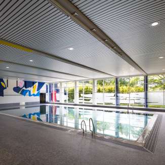 Modernes Hallenbad Resch in Schaan mit Wandkunst, großen Fenstern und Schwimmbecken in Liechtenstein